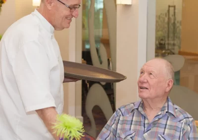 Chef serving a meal at Delmar Gardens of Lenexa