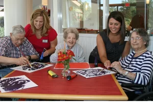 Delmar Gardens of Chesterfield with staff doing painting activities. The Delmar Gardens Family